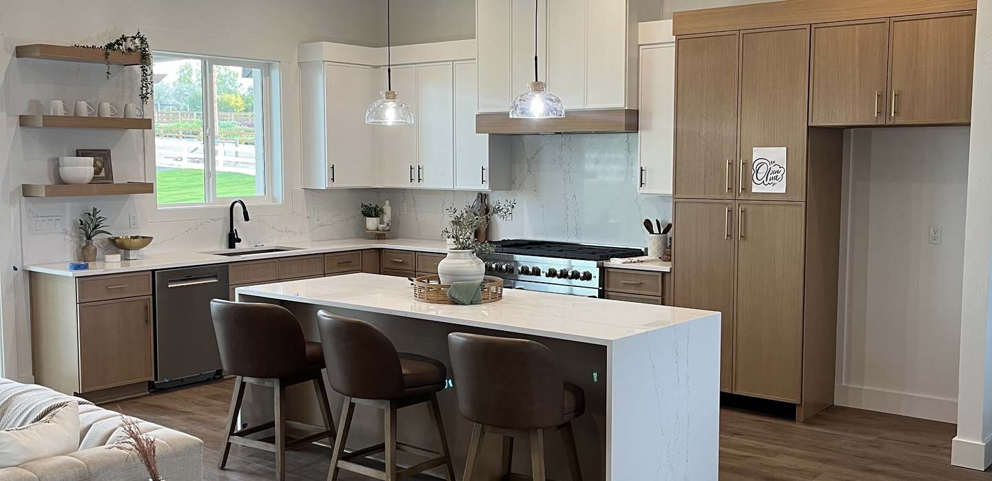 White oak and painted kitchen with quartz waterfall island, built by River City Cabinetry in Nampa Idaho